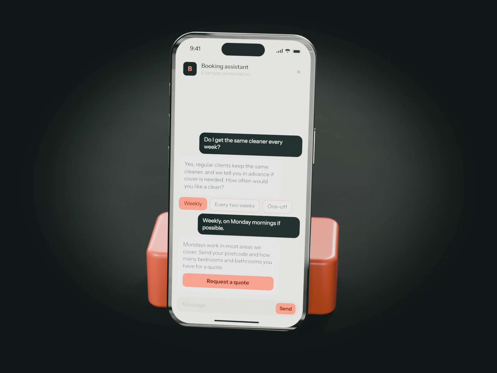 A phone on a coral stand showing an example chat with a cleaning company's booking assistant: a customer asks for the same cleaner every week and is asked for a postcode.