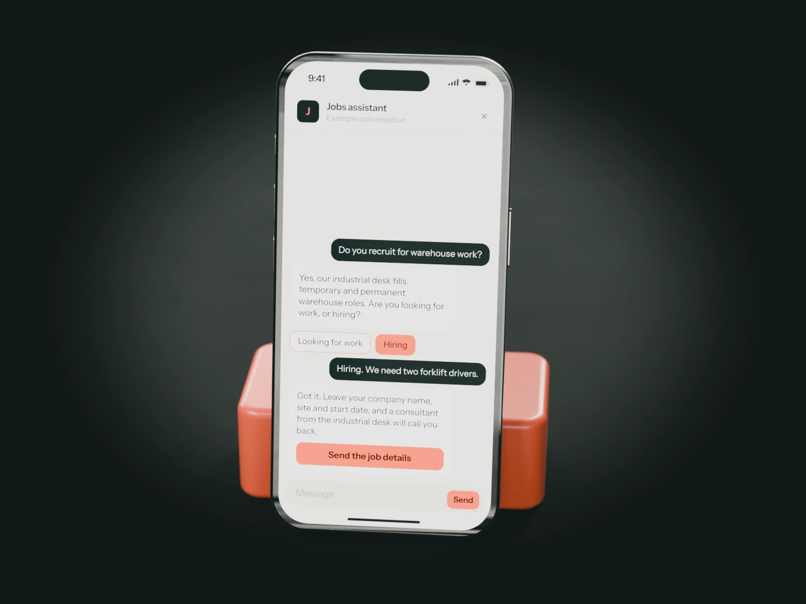 A phone on a coral stand showing an example chat with a recruitment agency's jobs assistant: a warehouse manager who needs forklift drivers is passed to the industrial desk.