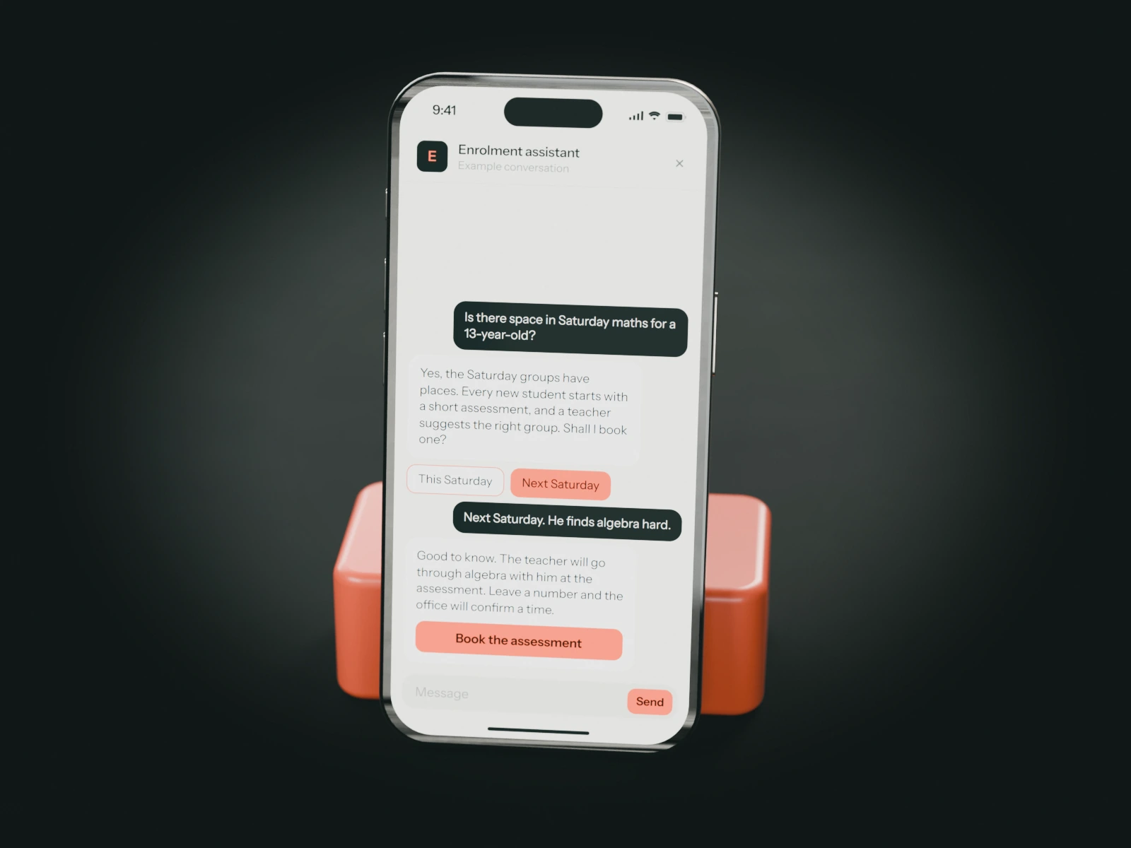 A phone on a coral stand showing an example chat with a tutoring centre's enrolment assistant: a parent asks about Saturday maths for a 13-year-old and is offered an assessment with a teacher.