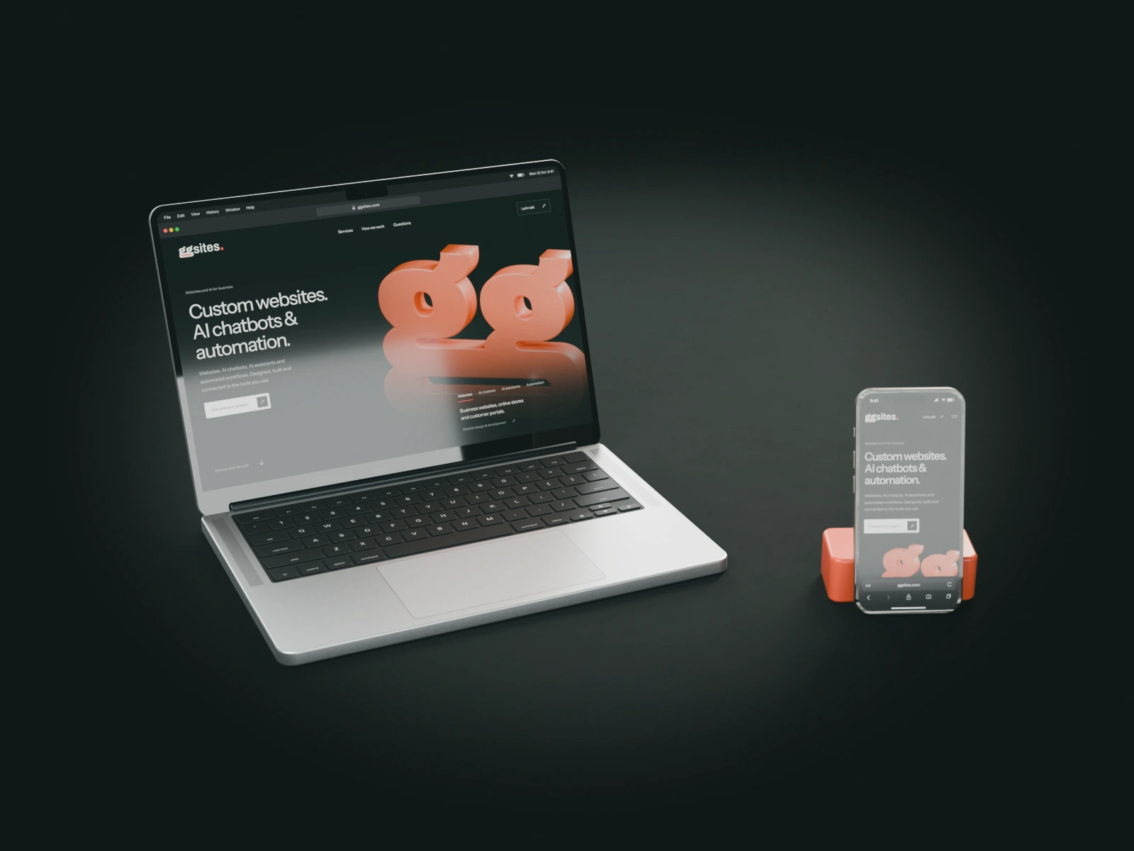 The GGSites homepage on a laptop and on a phone, rendered on a dark studio table.